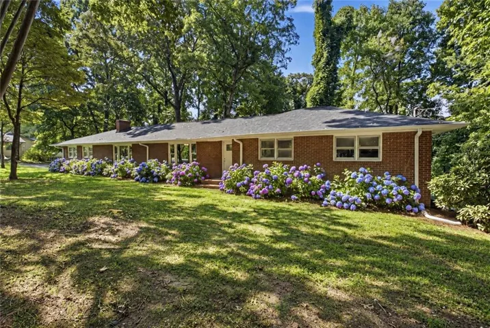 Brick exterior with white trim and a dark shingle roof