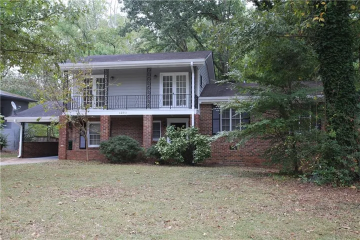Brick and siding exterior with a second-story balcony featuring black metal railing