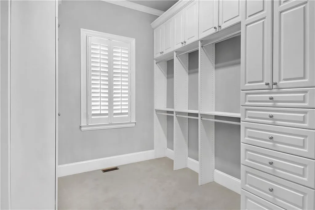 Spacious closet with light colored carpet
