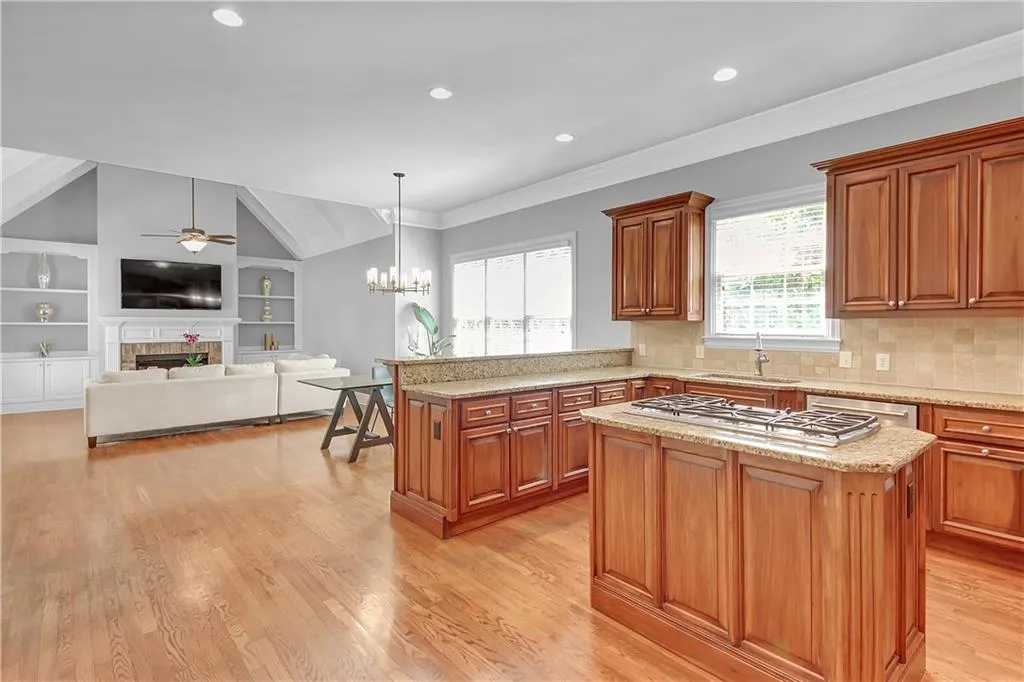 Kitchen featuring hanging light fixtures, a center island, light hardwood / wood-style floors, and backsplash