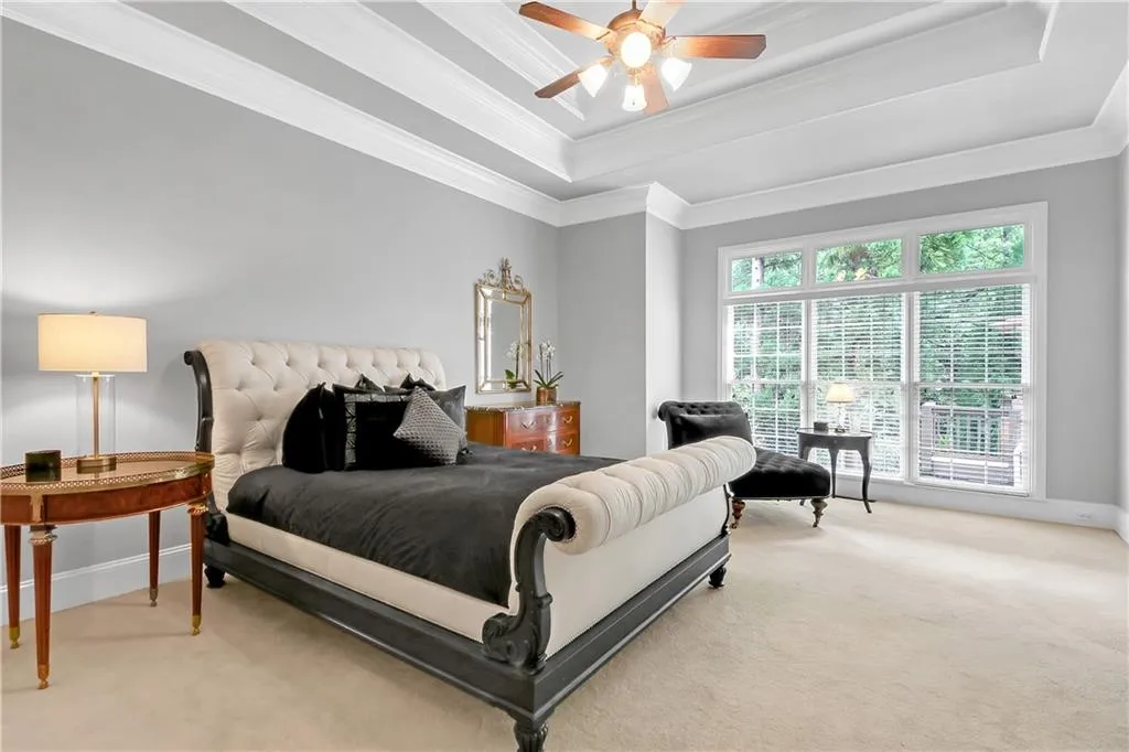 Bedroom with crown molding, a raised ceiling, and carpet floors