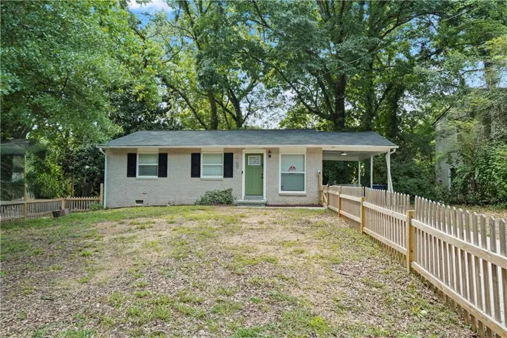 Classic ranch home featuring a covered front porch, fresh exterior paint in soft cream tones, black shutters and trim, and a welcoming entry with a sage green door