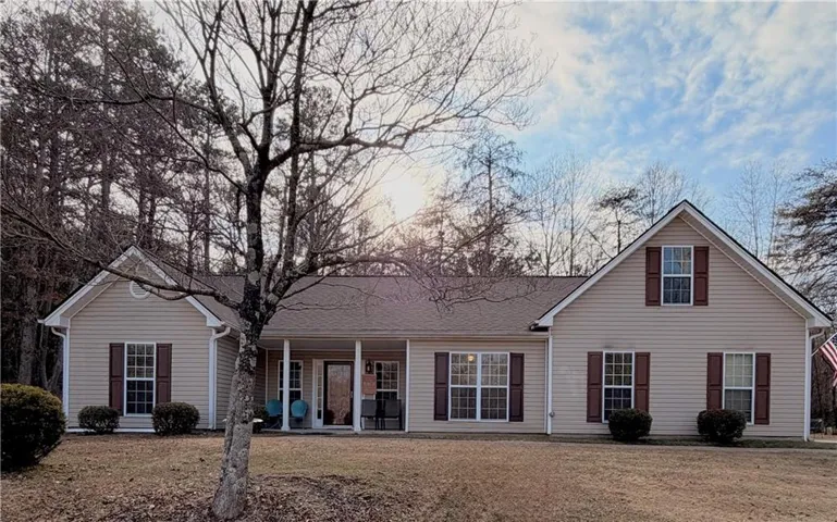 Rear view of property with a yard, roof with shingles, and a patio area