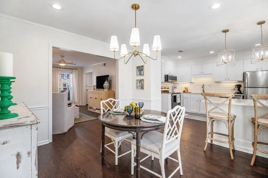 The kitchen and dining area shine with quartz countertops, classic subway tile backsplash, stainless steel appliances, gold accents, pantry space, and a breakfast bar perfect for casual dining.
