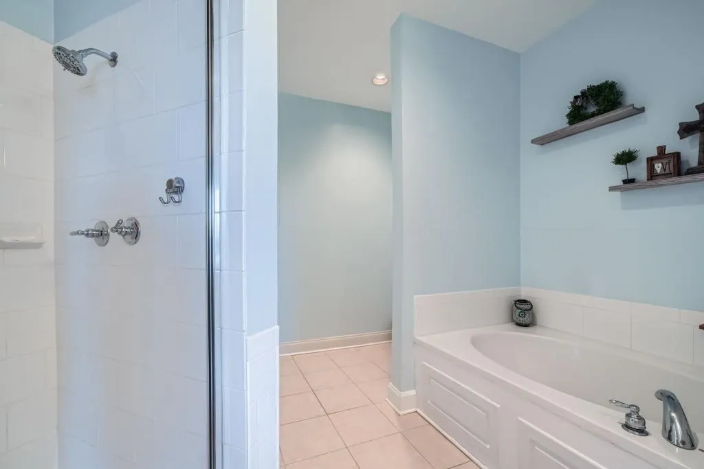 relax in the garden tub before rinsing off in the bright and light shower. The commode is tucked around the corner for privacy.