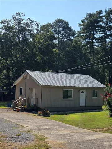Light-colored siding exterior with a metal roof