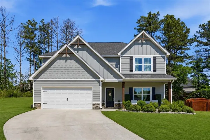 Two-story residence featuring a gray facade with vertical and shingle-style siding