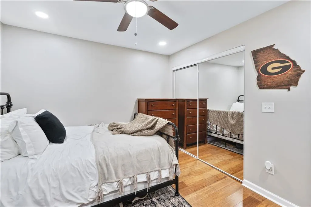 Bedroom featuring a closet, wood finished floors, a ceiling fan, and recessed lighting