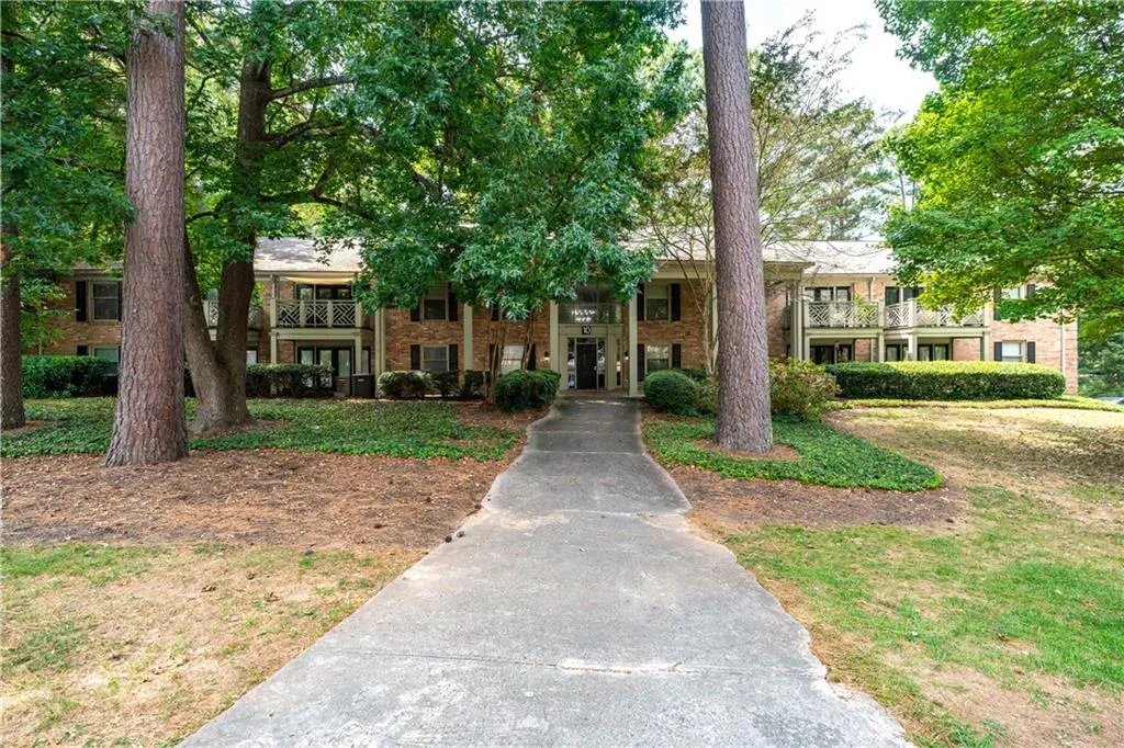 View of front of home featuring brick siding and a balcony