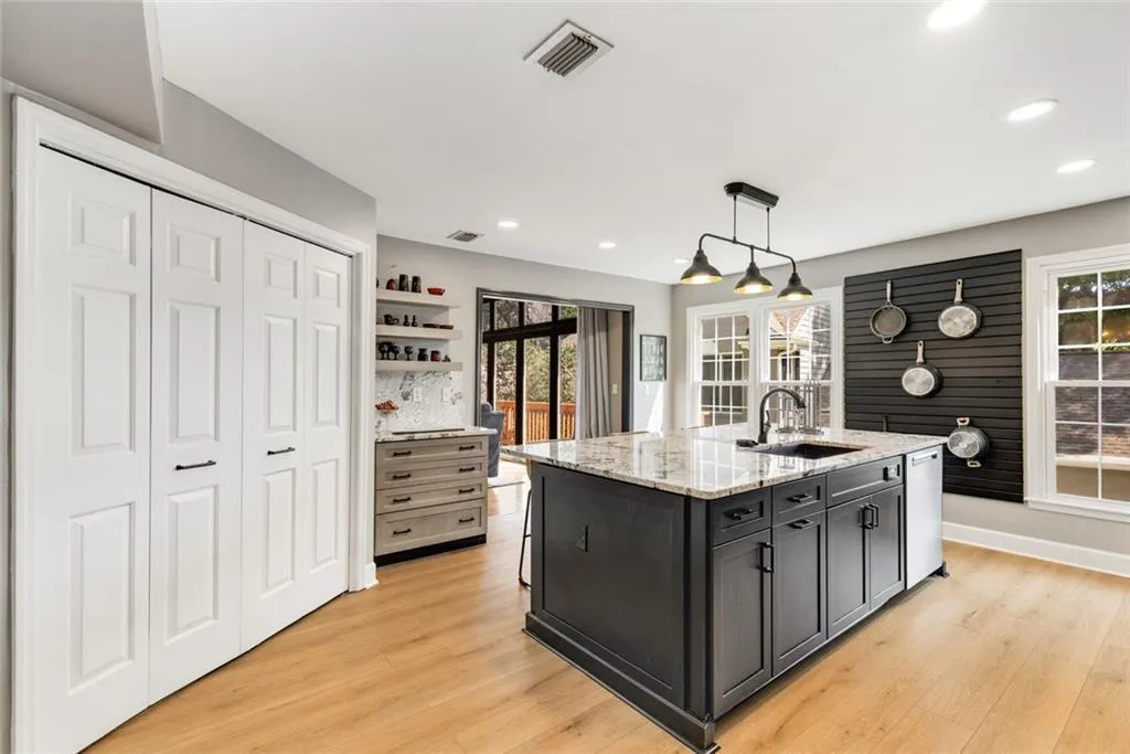 The double doors open for a full size laundry area. There is additional storage and shelving here too! Kitchen views to Living Room/Great Room.