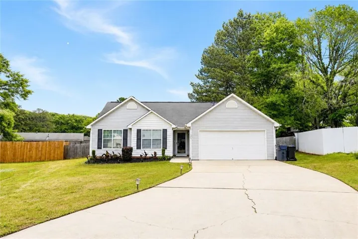 Light-colored siding exterior with a single-car garage and a paved driveway