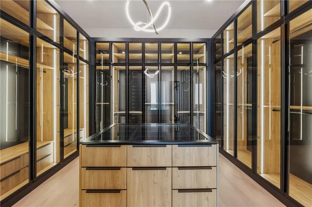 Custom LED-lit primary closet featuring rotating shoe and jewelry displays, tempered glass doors, and top-of-the-line European craftsmanship — a stunning, one-of-a-kind design that redefines luxury and organization. Custom LED-lit primary closet featuring rotating shoe and jewelry displays, tempered glass doors, and top-of-the-line European craftsmanship — a stunning, one-of-a-kind design that redefines luxury and organization.