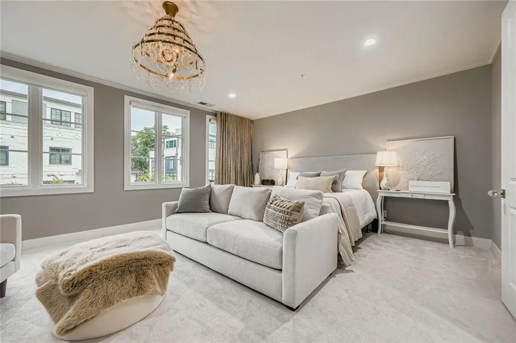 Bedroom with ornamental molding, light carpet, recessed lighting, remote control blinds and a chandelier