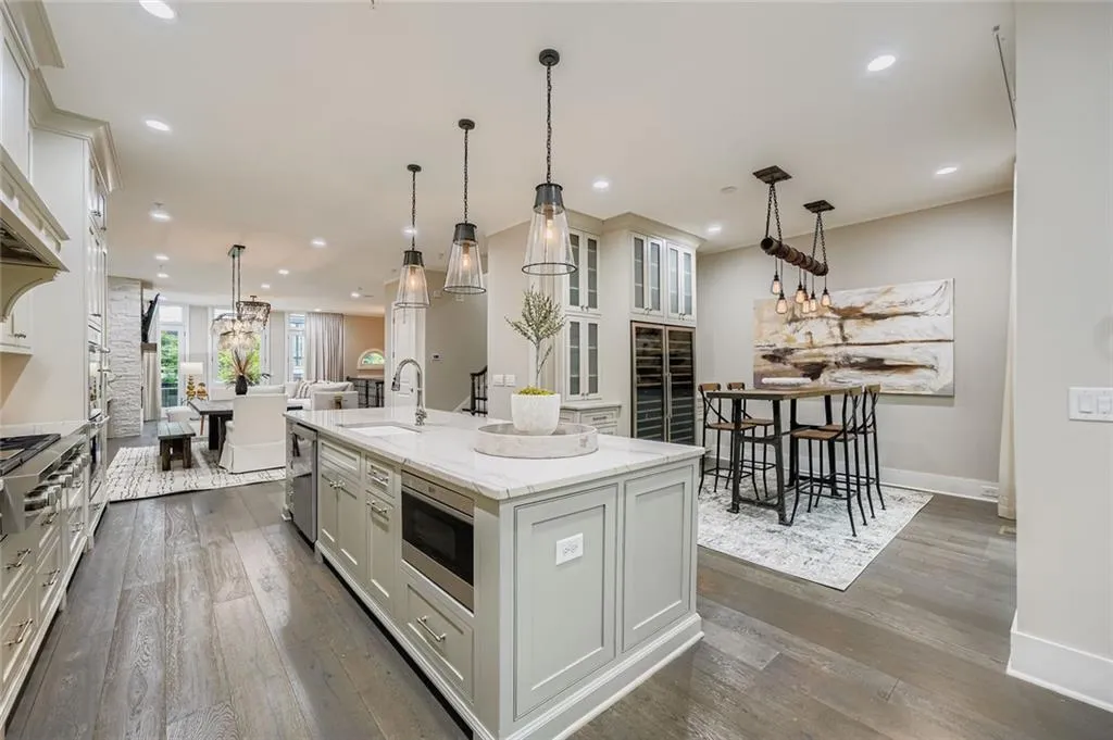 Kitchen with dark wood finished floors, an island with sink, open floor plan, wine cooler, and recessed lighting