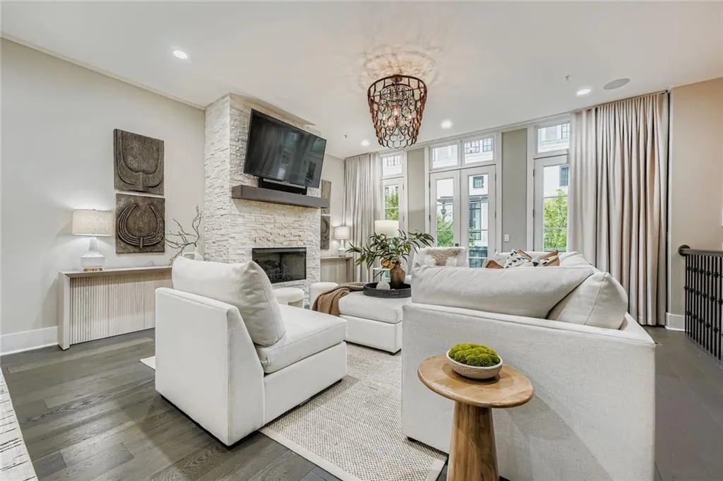 Living area with a stone fireplace, a chandelier, dark wood-style floors, recessed lighting, and radiator heating unit