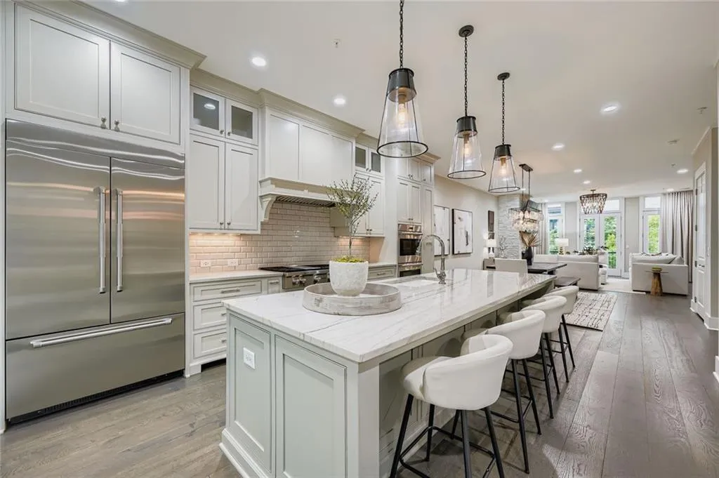 Kitchen with stainless steel appliances, backsplash, light wood-type flooring, open floor plan, and recessed lighting