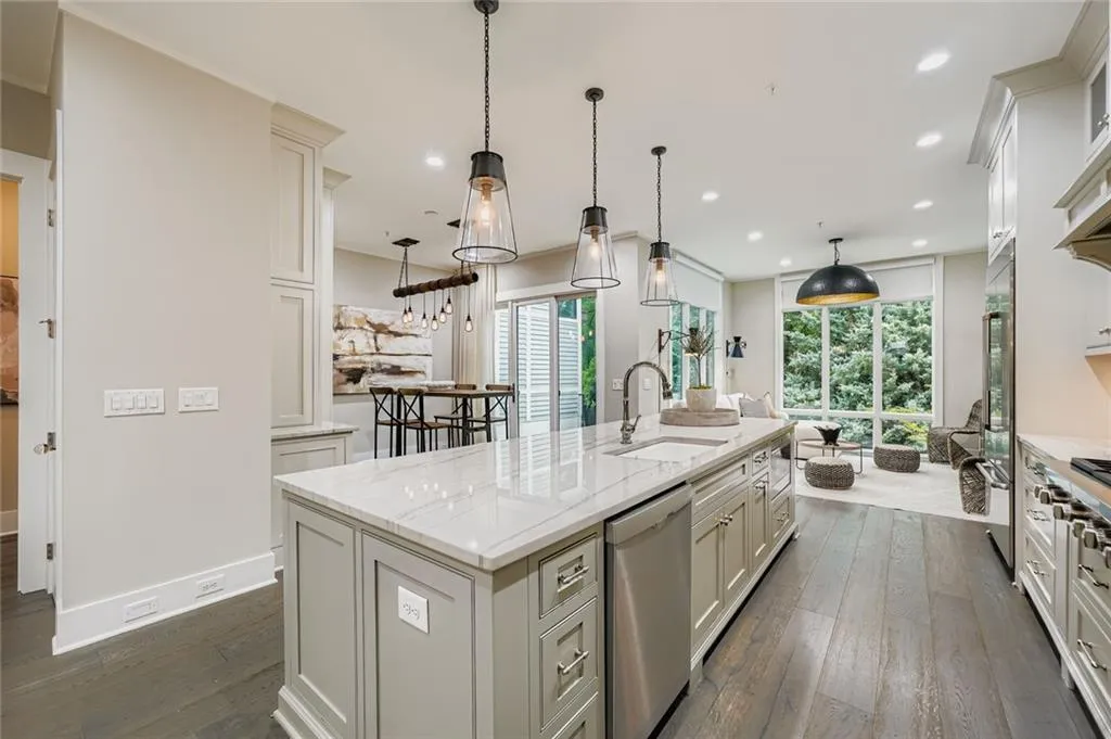 Kitchen with dark wood-type flooring, stainless steel appliances, a kitchen island with sink, plenty of natural light, and recessed lighting