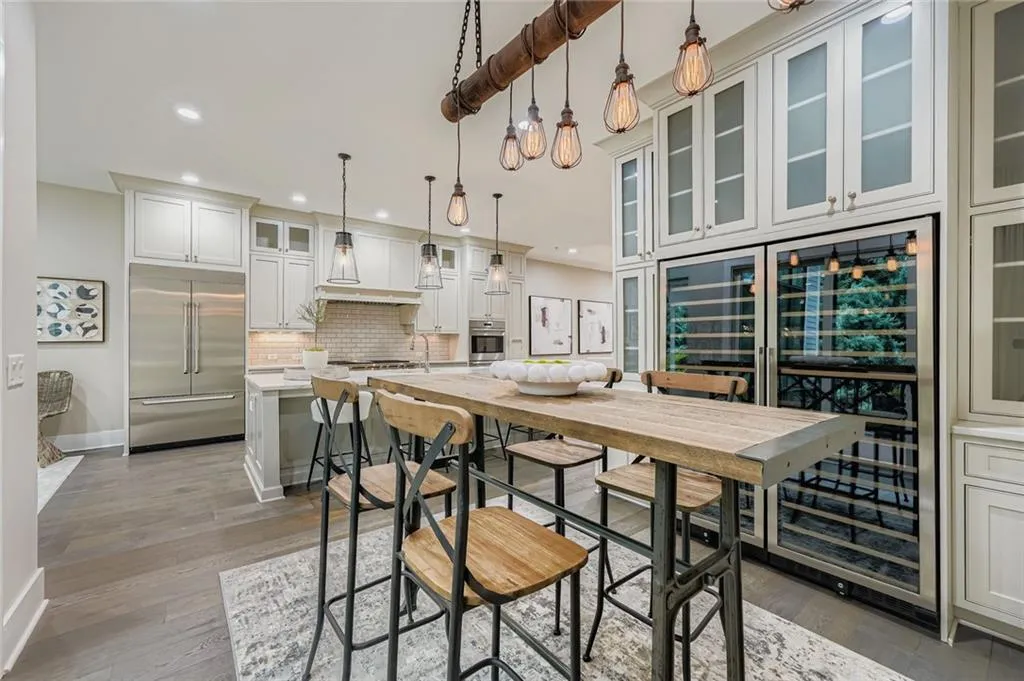 Dining space with wine cooler, wood finished floors, and recessed lighting