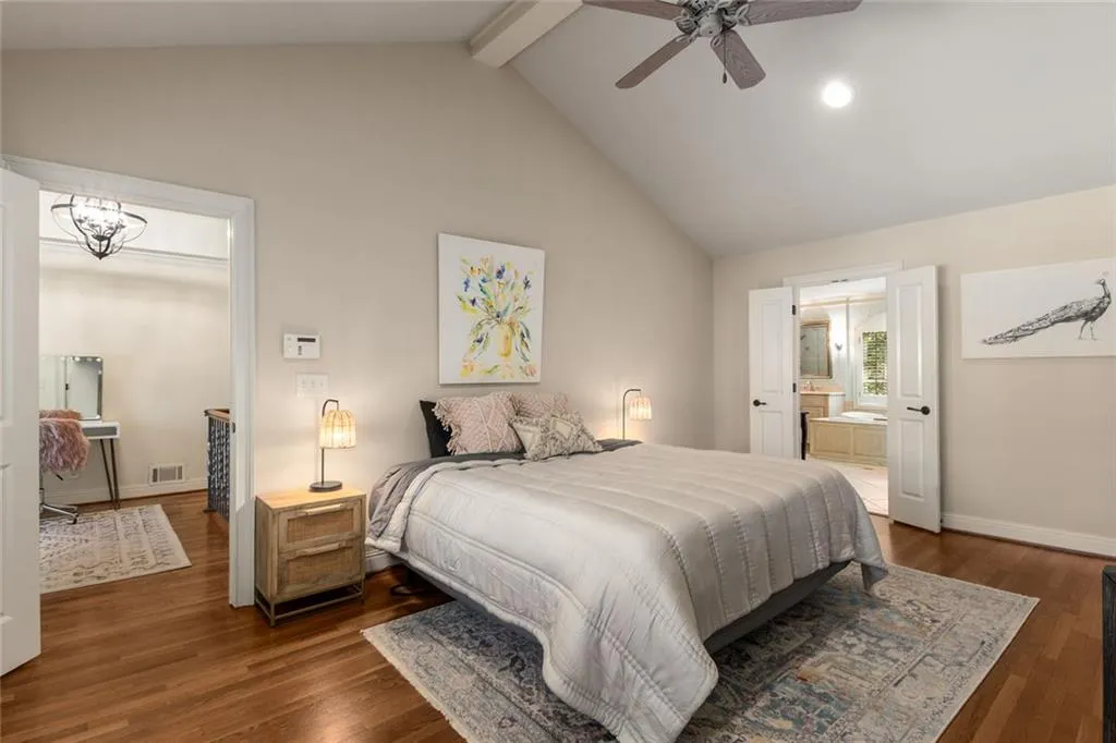 The primary suite features vaulted ceilings and a private bath complete with double vanities, a soaking tub, separate shower, and a walk-in closet with custom storage solutions.