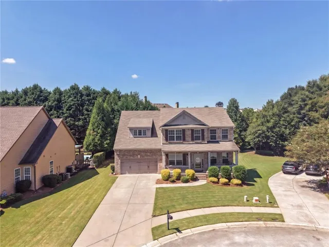 Two-story residence with a brick and siding exterior, front porch, and a two-car garage