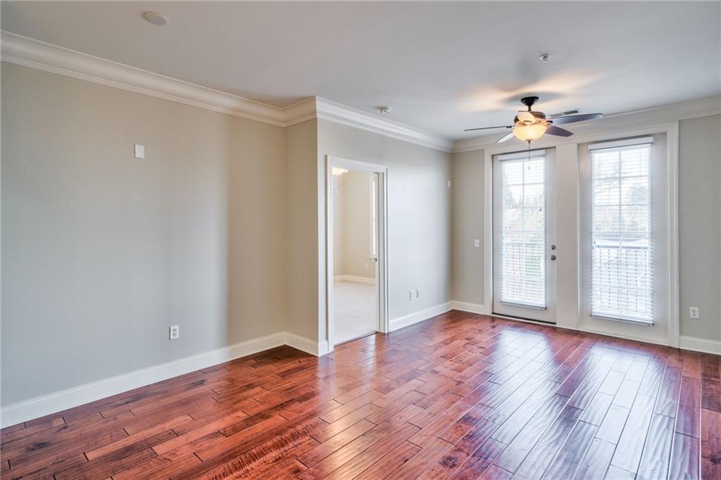 Empty room with crown molding, dark hardwood / wood-style floors, and ceiling fan