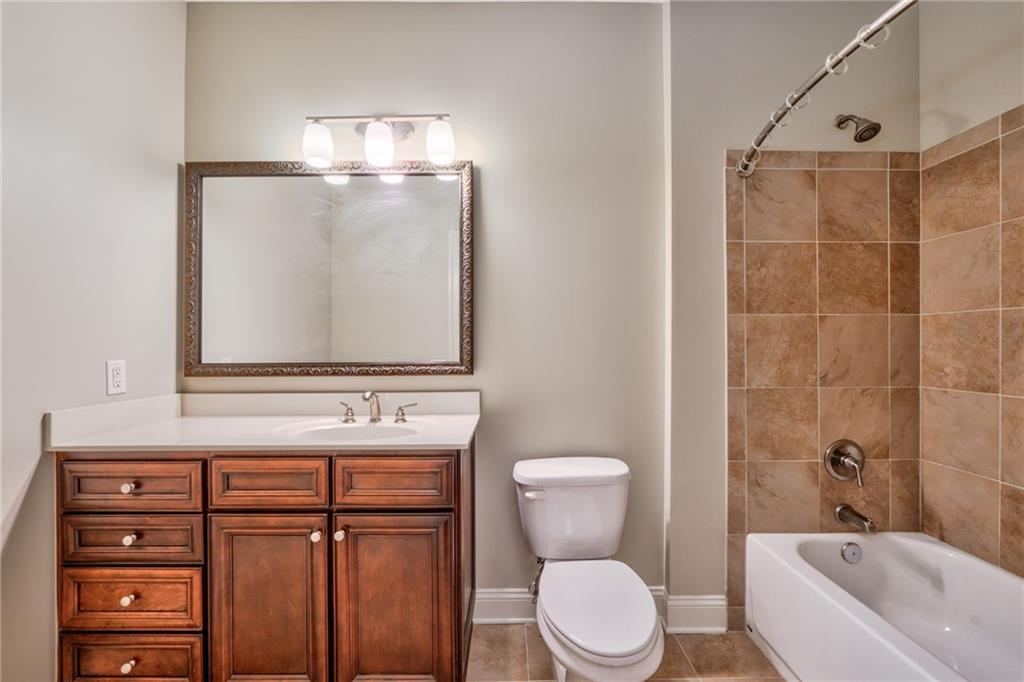 Full bathroom featuring tile floors, tiled shower / bath, toilet, and vanity