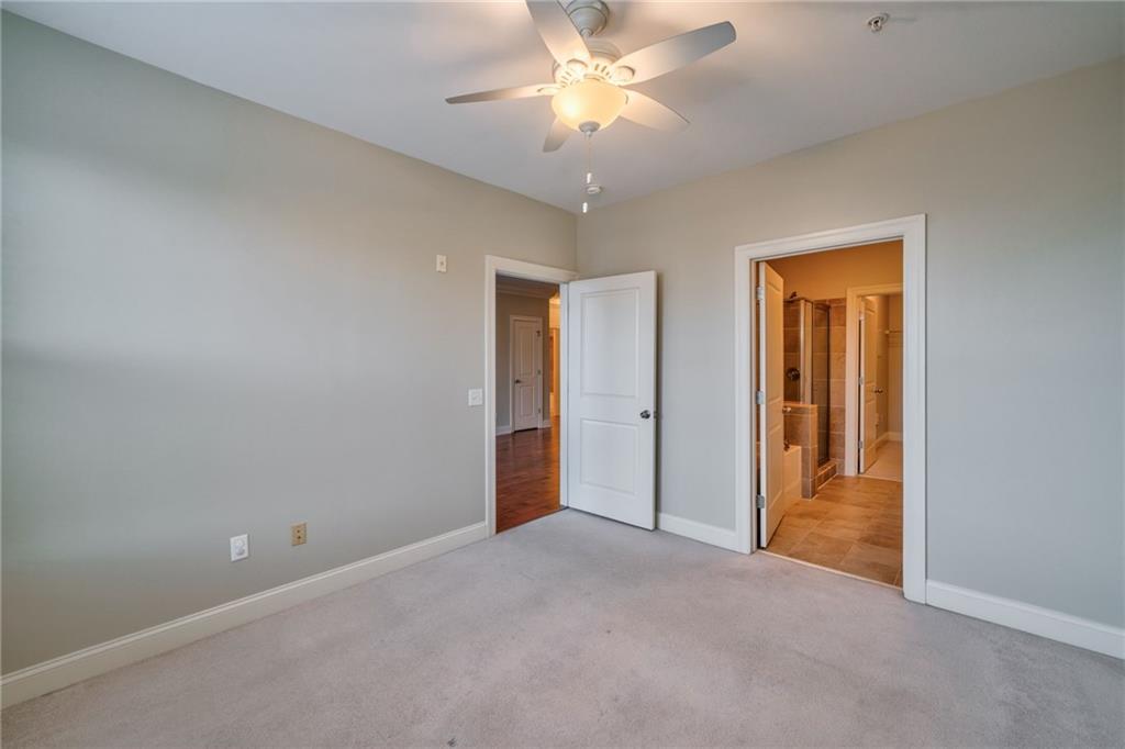 Unfurnished room with light colored carpet and ceiling fan