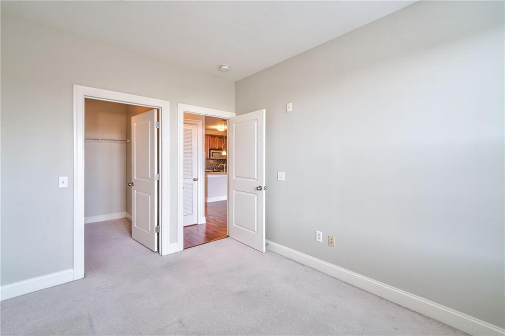 Unfurnished bedroom with a closet, light colored carpet, and a spacious closet