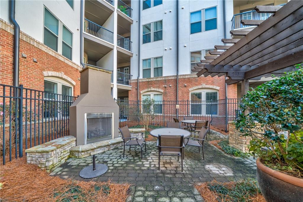 View of patio featuring an outdoor fireplace and a pergola