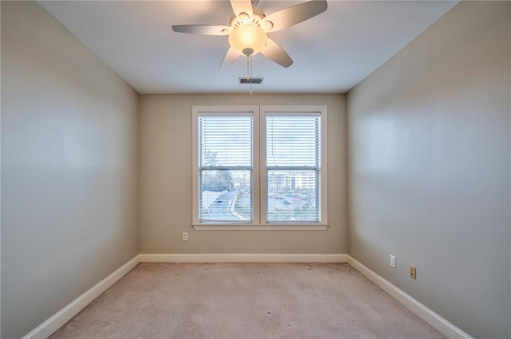 Carpeted empty room featuring ceiling fan