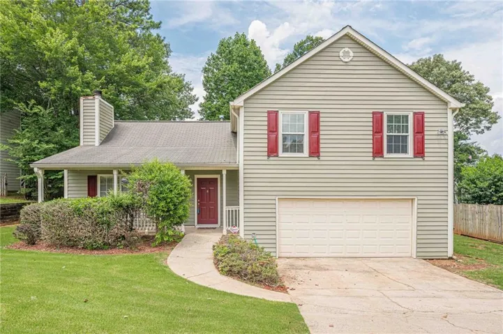 Light-colored siding exterior featuring red shutters, an attached two-car garage, and a covered front porch with white columns