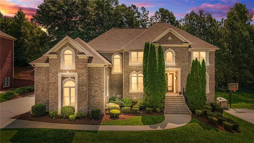 Stately brick exterior featuring a multi-gabled roofline and arched windows