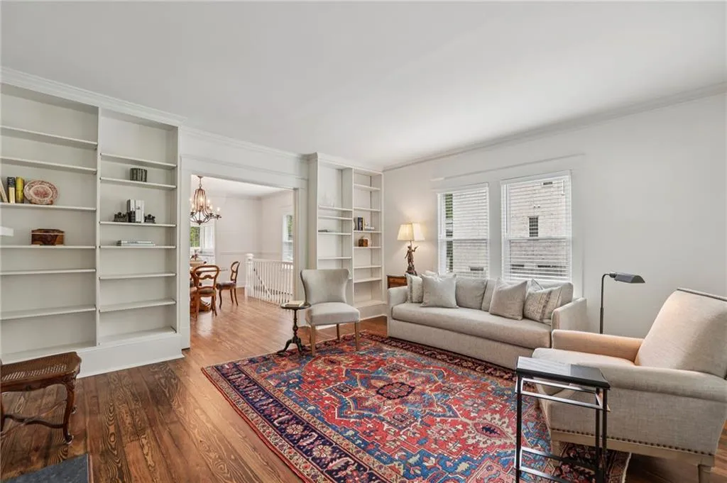 Living area with built in features and refinished wood floors