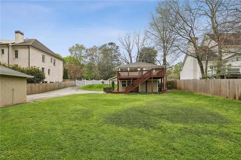 Fenced backyard with a deck and patio. 2-car garage on the left