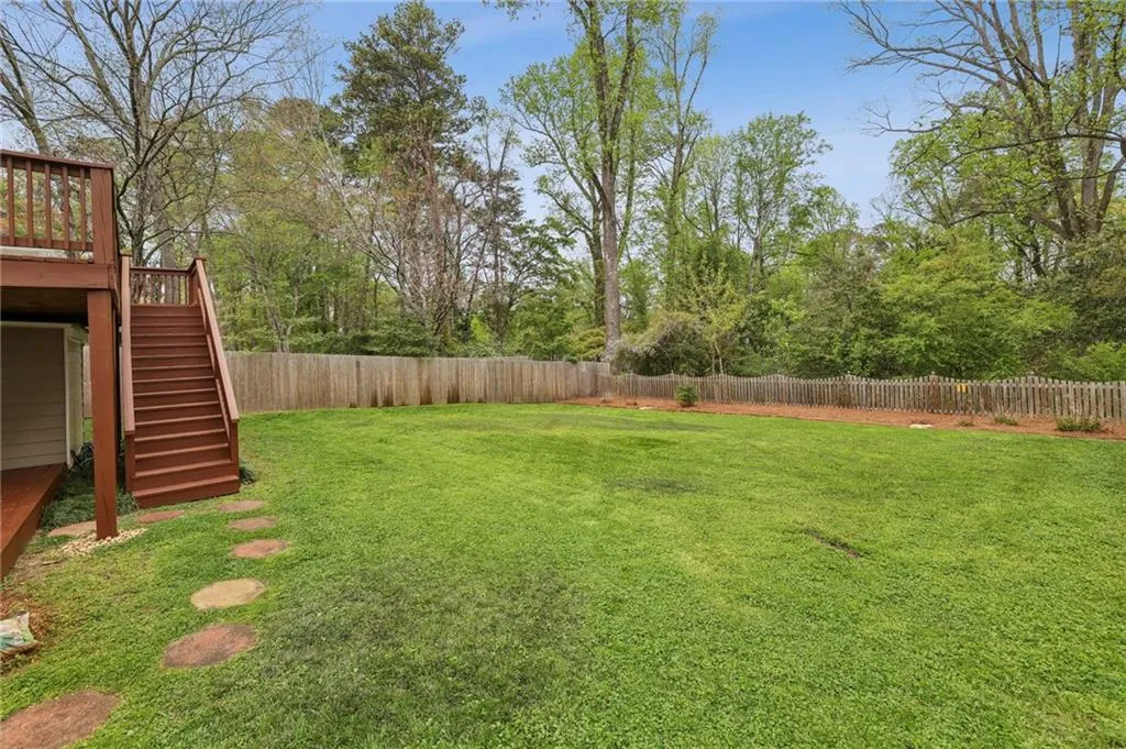 Fenced backyard with stairs and a deck