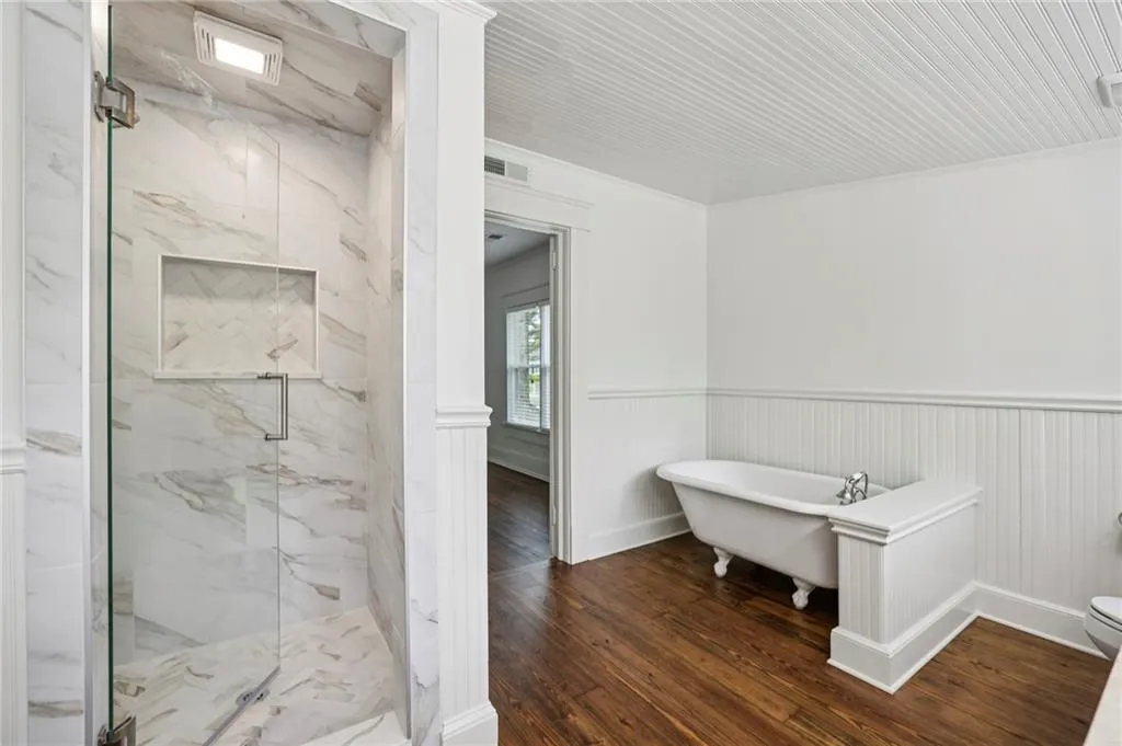 Full bathroom with marble finish shower, and freestanding bath tub