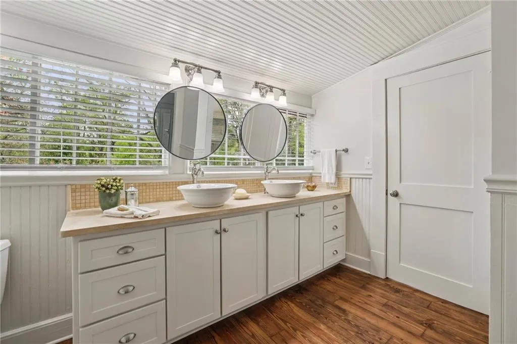Bathroom featuring double vanity, and wood floors