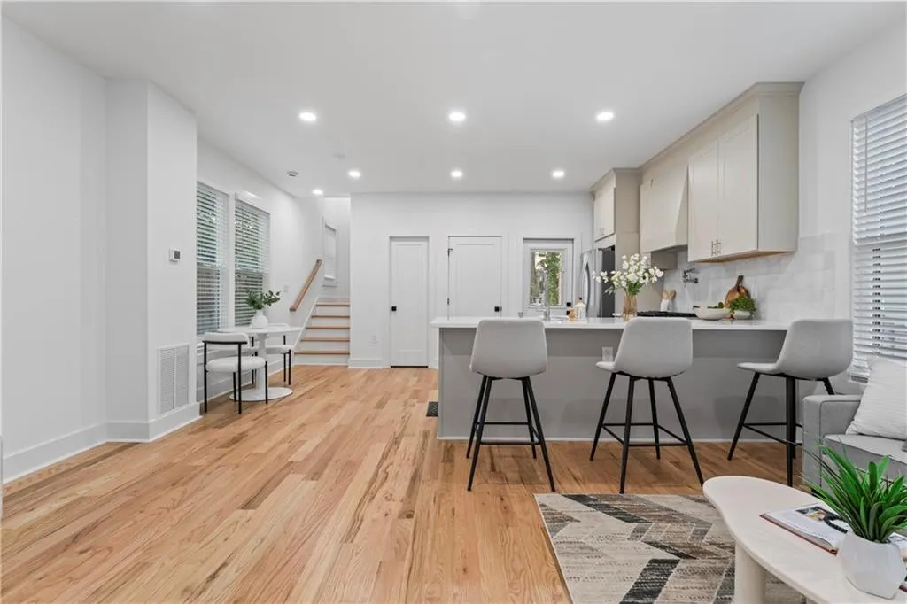 Kitchen with light wood-style floors, recessed lighting, a peninsula, a breakfast bar area, and tasteful backsplash