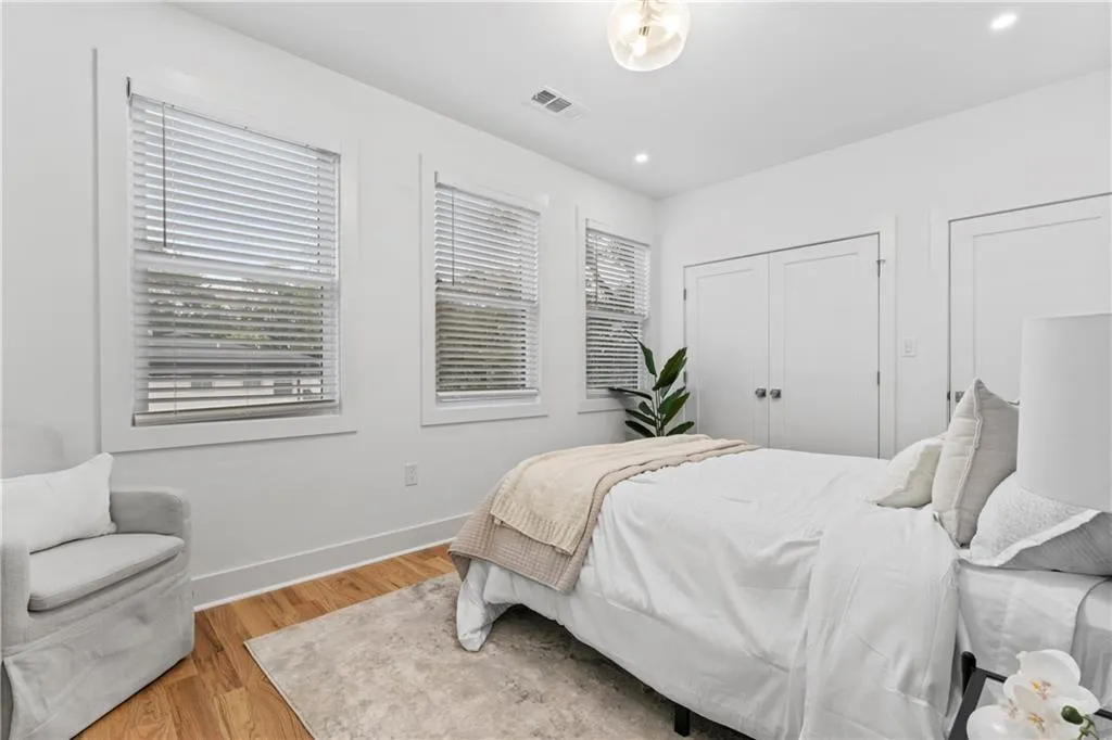 Bedroom with wood finished floors, recessed lighting, and a closet