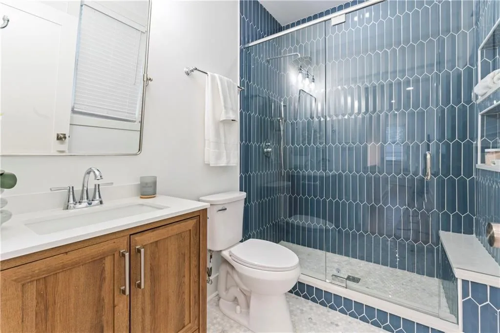 Full bathroom featuring vanity, a stall shower, and tile patterned flooring