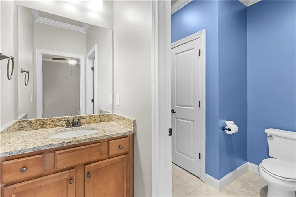 Bathroom featuring crown molding, vanity, a ceiling fan, and light tile patterned floors