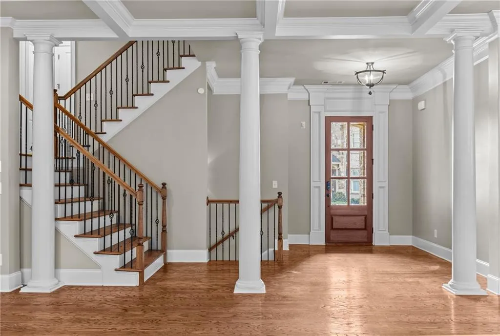Entryway with decorative columns, light wood-style flooring, and crown molding