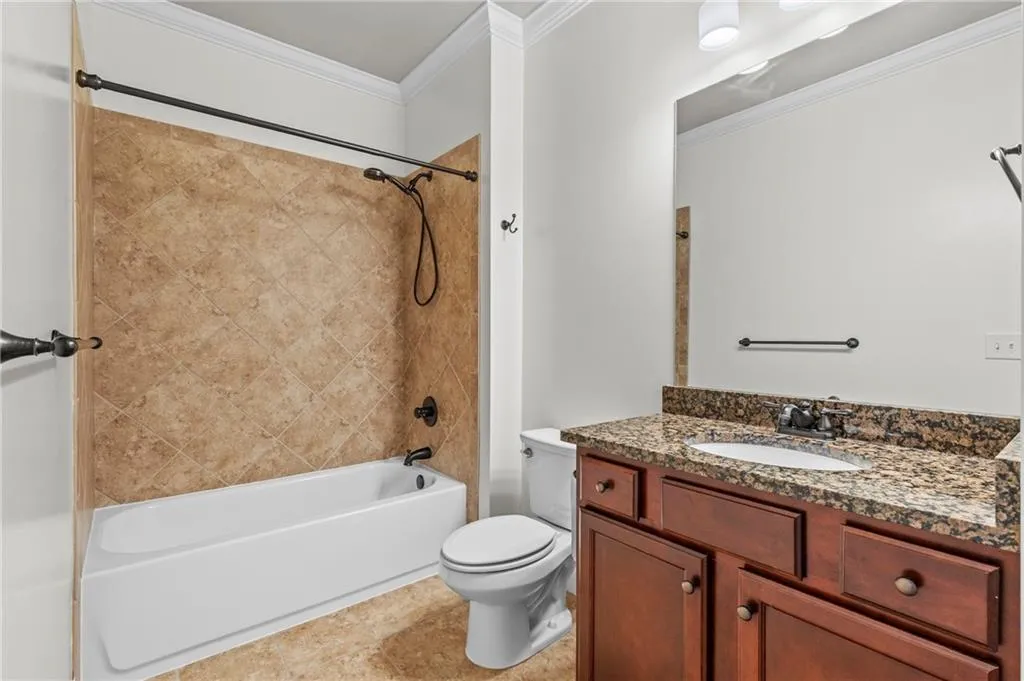 Full bath with shower / bathtub combination, crown molding, and vanity