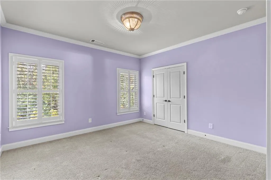 Unfurnished bedroom with ornamental molding, carpet, and a closet