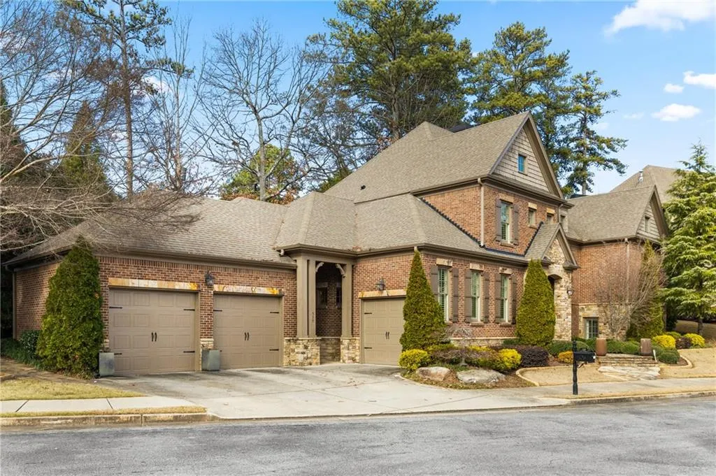 View of front of home featuring brick siding, a shingled roof, concrete driveway, and an attached garage