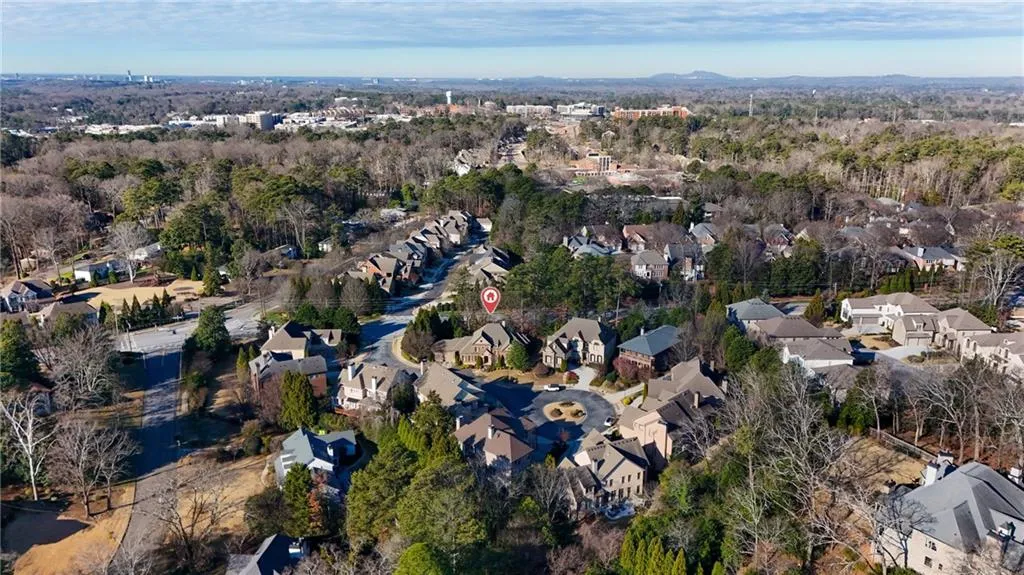 View of property location featuring nearby suburban area and a heavily wooded area