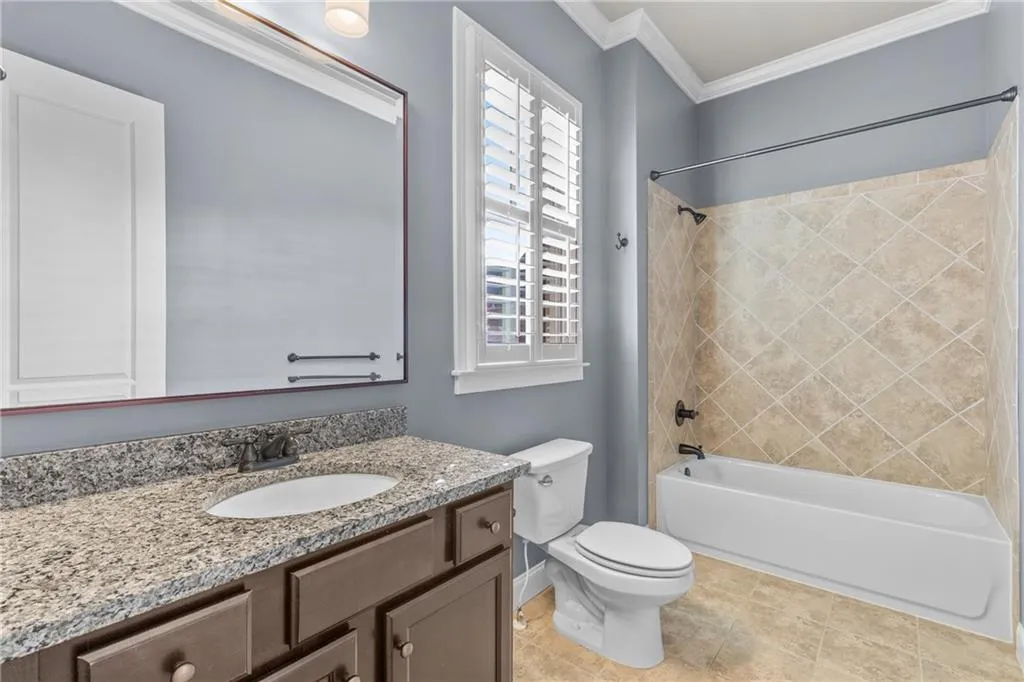 Full bathroom featuring shower / washtub combination, vanity, and ornamental molding