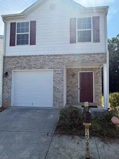 Two-story exterior with brick and siding facade, front-facing garage, covered entry, and decorative window shutters