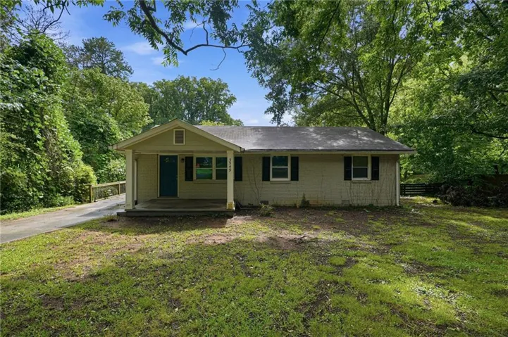 Ranch-style exterior with a covered front porch, a blue entry door, and dark window shutters