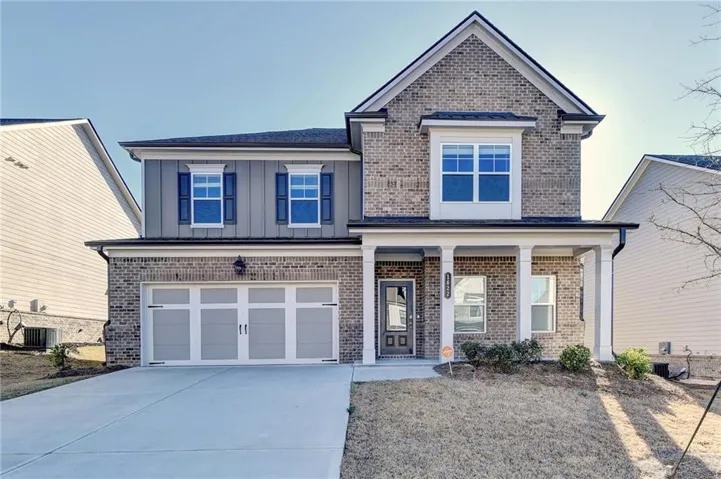 Two-story brick and siding exterior with a covered porch entry